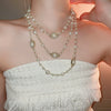 Wholesale Women's Metal And Imitation Pearl Sweater Chain Necklace With Flower Pattern And Light Luxury Style Set With Pearls