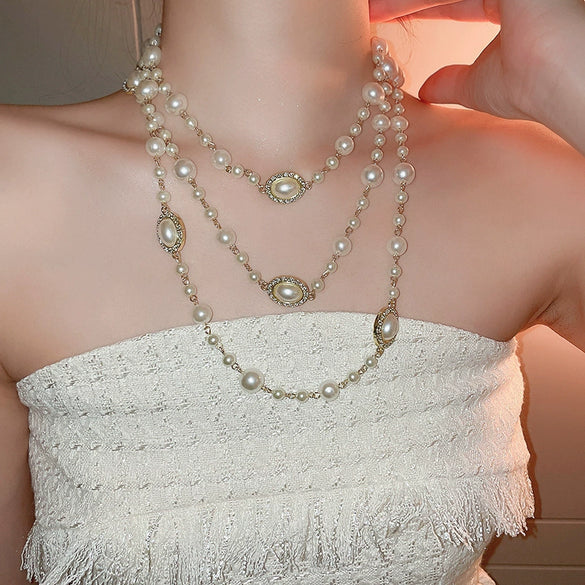 Wholesale Women's Metal And Imitation Pearl Sweater Chain Necklace With Flower Pattern And Light Luxury Style Set With Pearls