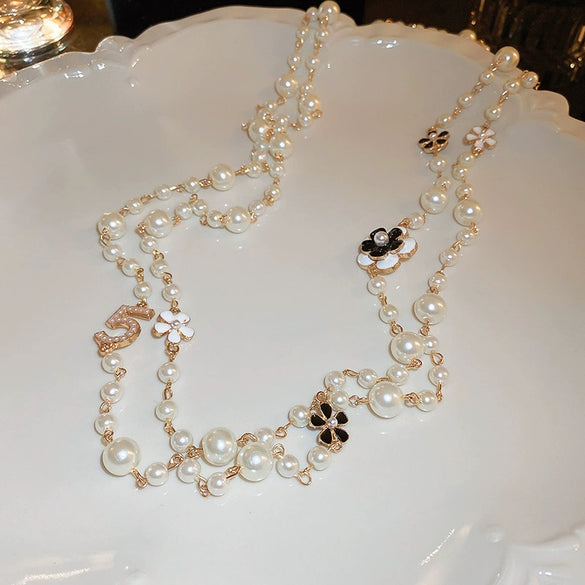 Wholesale Women's Metal And Imitation Pearl Sweater Chain Necklace With Flower Pattern And Light Luxury Style Set With Pearls