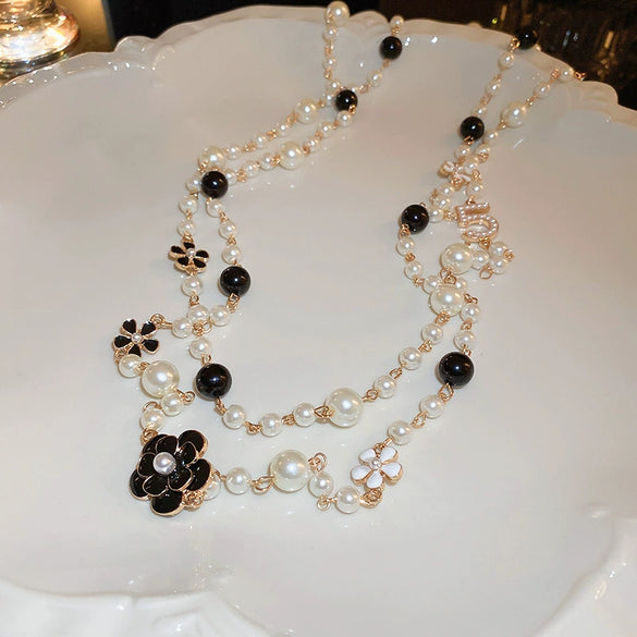 Wholesale Women's Metal And Imitation Pearl Sweater Chain Necklace With Flower Pattern And Light Luxury Style Set With Pearls